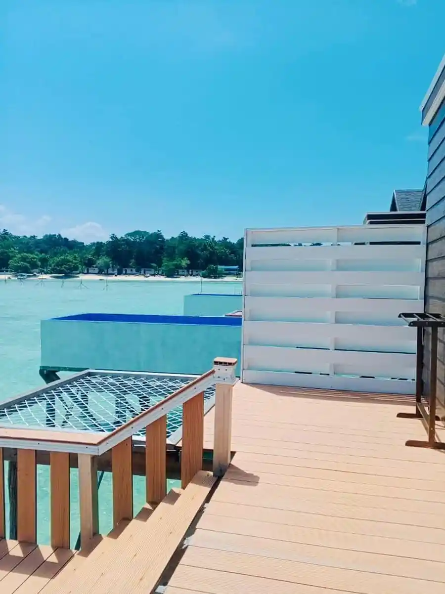 Outdoor wooden deck of the Bedroom Deluxe 1 Bed at Turtle Seaweed Resort featuring an overwater hammock net and beautiful sea views.